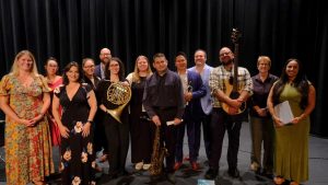 A group of musicians holding instruments standing on a stage.
