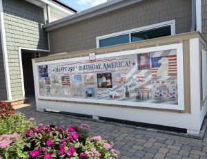 photo of a large outdoor wall panel featuring multiple drawings by children